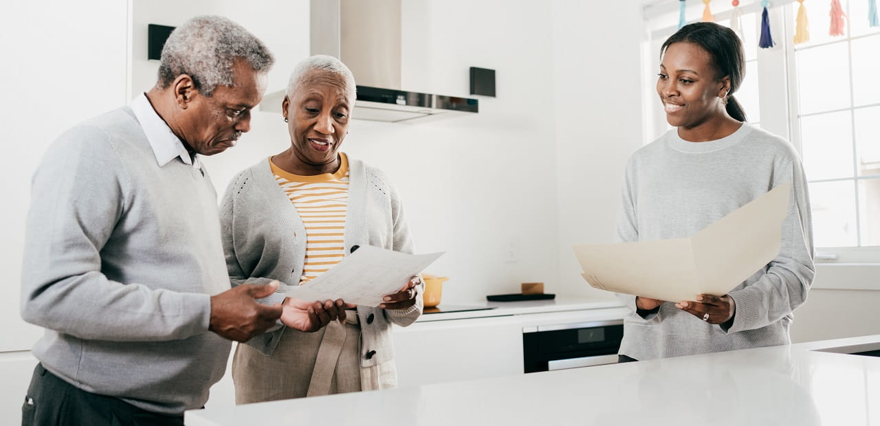 Insurance broker and senior couple at home with folders.