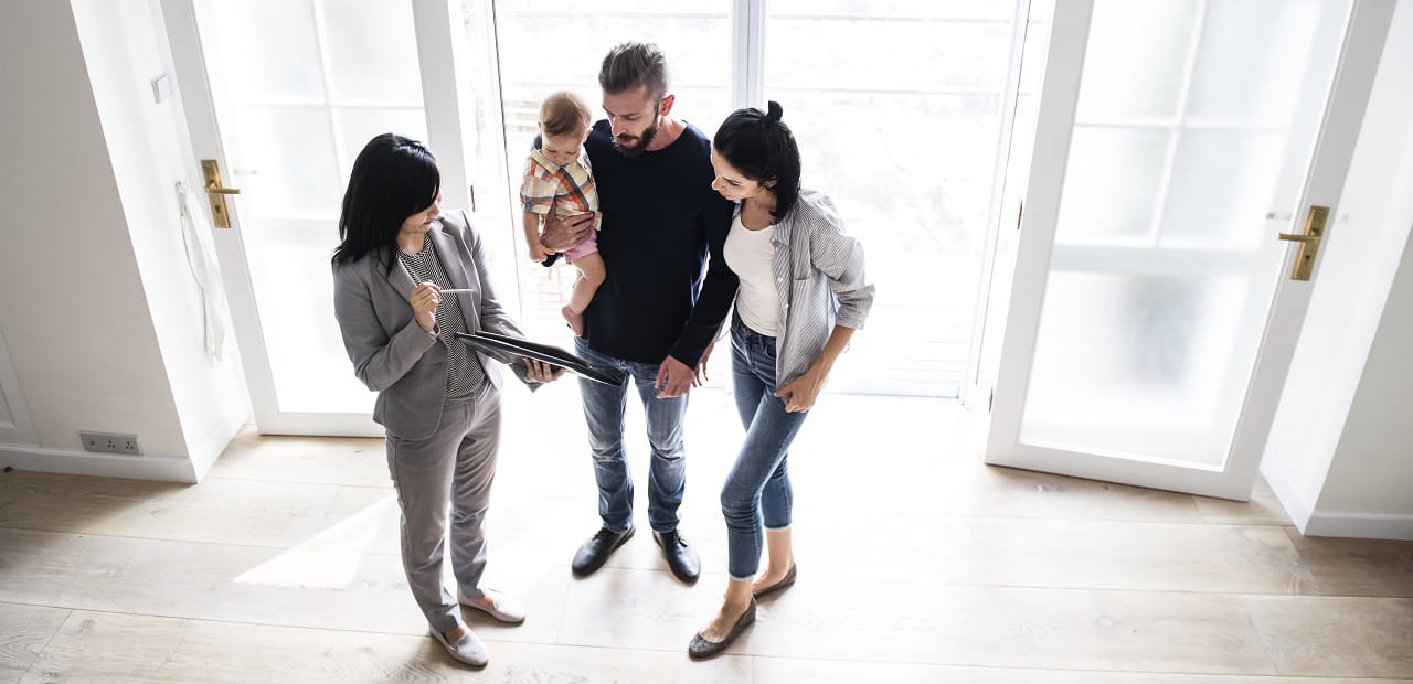 Family speaking with real estate agent in a home.